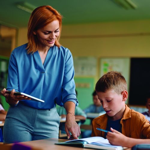 5mpfv_stock-photo-happy-elementary-school-teacher-assisting-her-student-with-learning-during-a-class-in-th.jpg